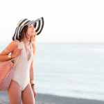 Woman on beach enjoy her smooth skin- the answer to what is laser hair removal in Naperville